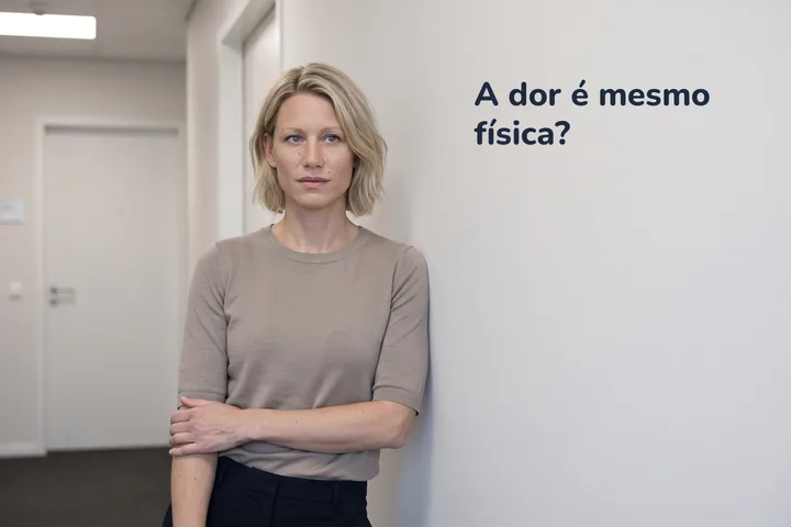 A dor é mesmo física? — uma mulher para no corredor do escritório com o antebraço cruzado sobre a barriga