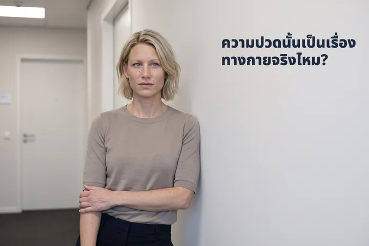 ความปวดนั้นเป็นเรื่องทางกายจริงไหม? — หญิงคนหนึ่งหยุดเดินกลางทางเดินในออฟฟิศ ท่อนแขนกดทาบไว้กลางลำตัว