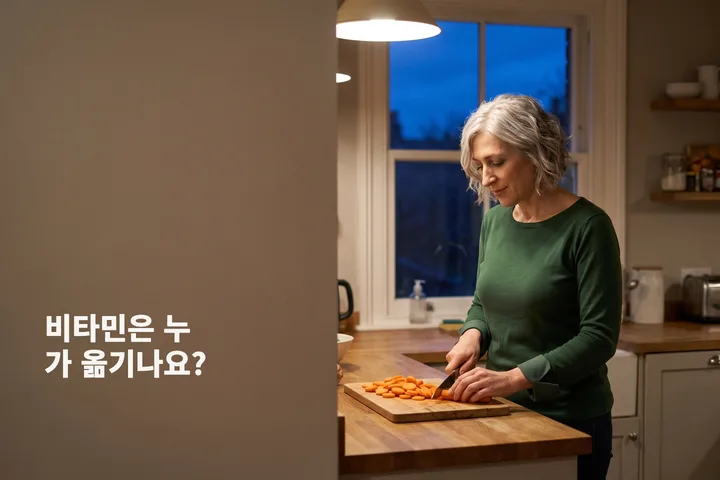 비타민은 누가 옮기나요? — 한 여자가 저녁 등불 아래 주방 조리대에서 당근을 썬다