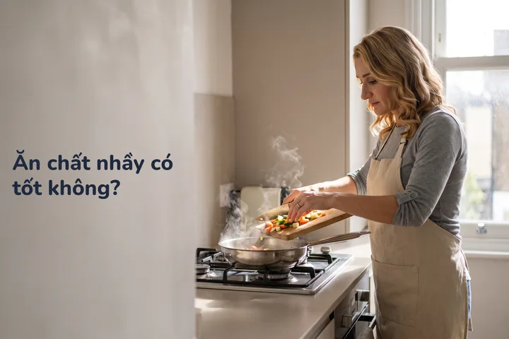 Ăn chất nhầy có tốt không? — một phụ nữ ngoài bốn mươi trút rau đã thái vào chảo trong gian bếp buổi sáng