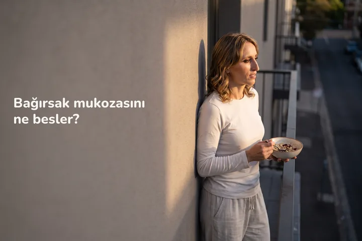 Bağırsak mukozasını ne besler? — yirmili yaşlarda bir kadın son güneşte balkonunda bir kâse yulaf yiyor