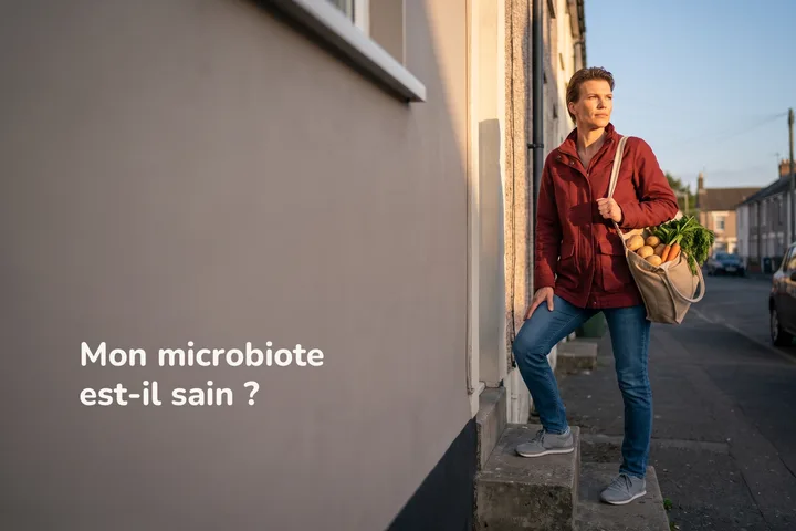 Mon microbiote est-il sain ? — une femme monte les marches de sa maison le soir avec un sac de légumes