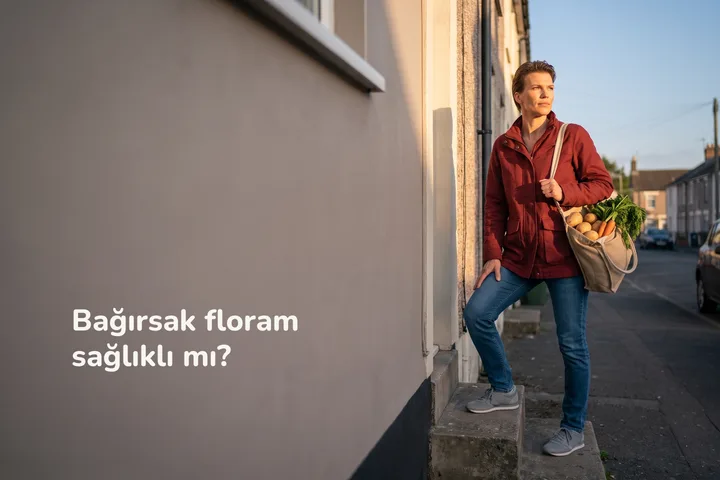Bağırsak floram sağlıklı mı? — bir kadın akşamüstü elinde sebze torbasıyla evinin merdivenlerini çıkıyor