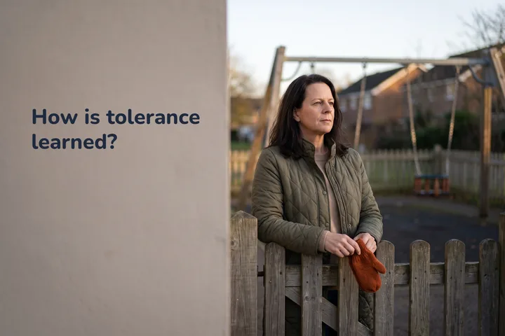 How is tolerance learned? — a woman stops at an empty playground gate in low late-afternoon sun