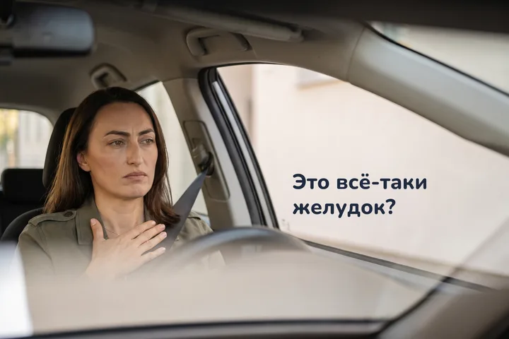 Это всё-таки желудок? — женщина в припаркованной машине утром, ладонь лежит на животе