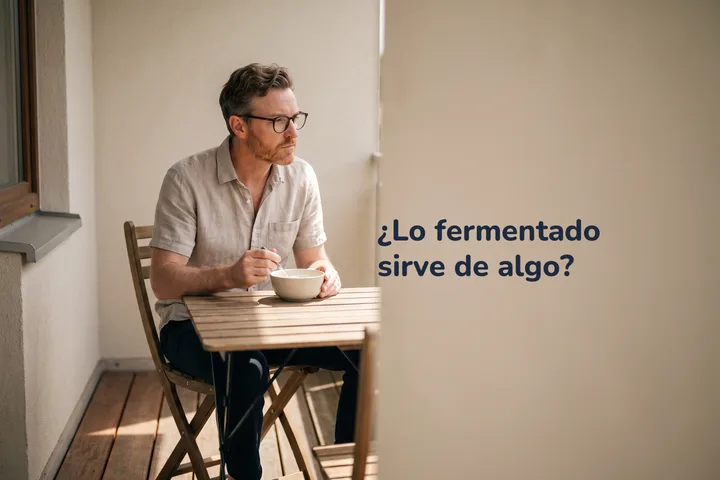 ¿Lo fermentado sirve de algo? — un hombre come un tazón de kéfir en una mesita de su balcón por la tarde