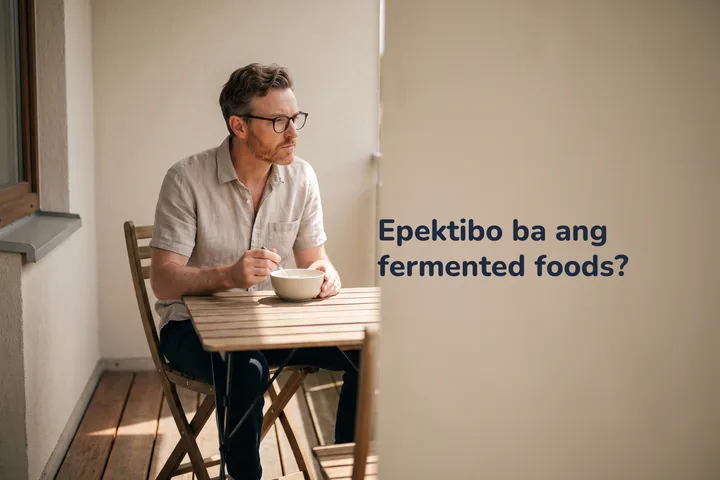 Epektibo ba ang fermented foods? — kumakain ang isang lalaki ng kefir sa maliit na mesa sa balkonahe niya sa hapon